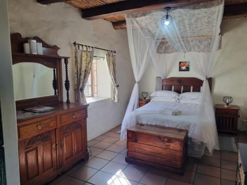 a bedroom with a bed and a dresser and a mirror at Fairfield Cottages in Ceres