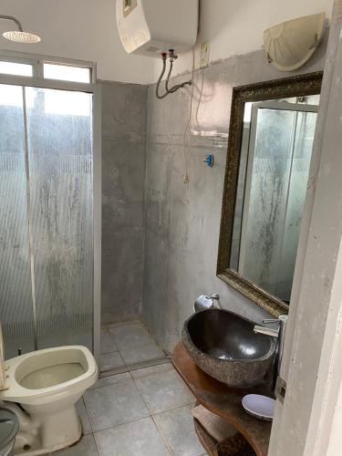 a bathroom with a sink and a toilet and a mirror at Casa para 6 personas con vista al mar Cumbre del Diablo 3 in Punta Del Diablo