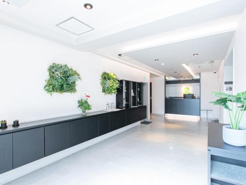 eine Bürolobby mit Pflanzen an der Wand in der Unterkunft HOTEL Calmplace in Kanda