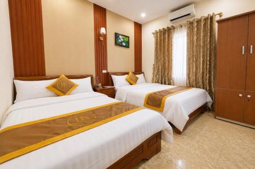 a hotel room with two beds and a television at Bảo Ngọc Cô Tô hotel in Đảo Cô Tô