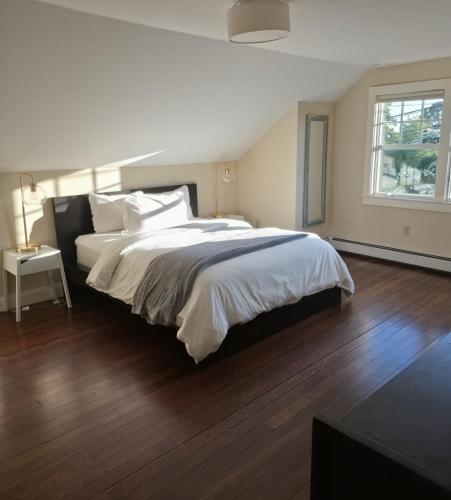 a bedroom with a large bed and a wooden floor at Middletown Bungalow w/Hot Tub and Private Yard - RIBryan Properties in Middletown