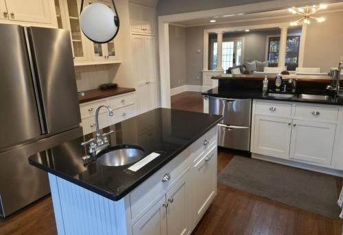 a kitchen with a sink and a refrigerator at Middletown Bungalow w/Hot Tub and Private Yard - RIBryan Properties in Middletown