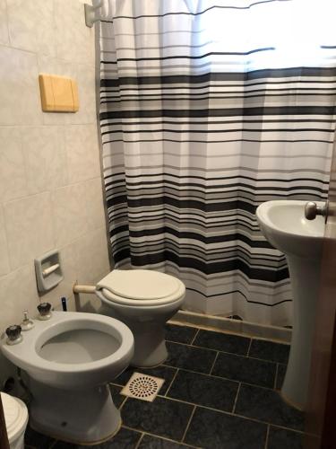 a bathroom with a toilet and a shower curtain at Brisas del Diablo 1 in Punta Del Diablo