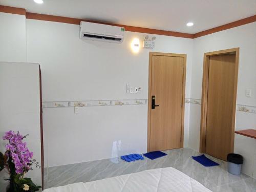 a room with a bed and a door with blue sheets at Mekong Rose 2 in Bình Thủy