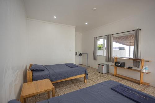 a bedroom with two beds and a window at SARDINEBAY Dive Resort in Moalboal