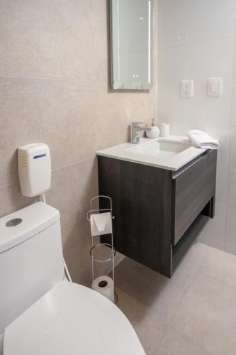 a bathroom with a white toilet and a sink at 1503 A - INARA Downtown Four in Guatemala