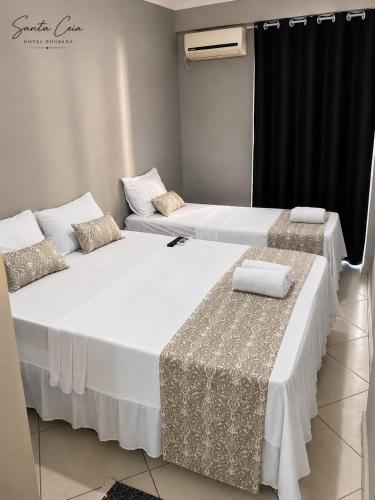two large beds in a room with two chairs at Hotel Pousada Santa Ceia in Aparecida