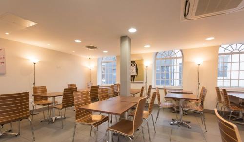 a dining room with tables and chairs and windows at Britannia Study Hotel in Brighton & Hove