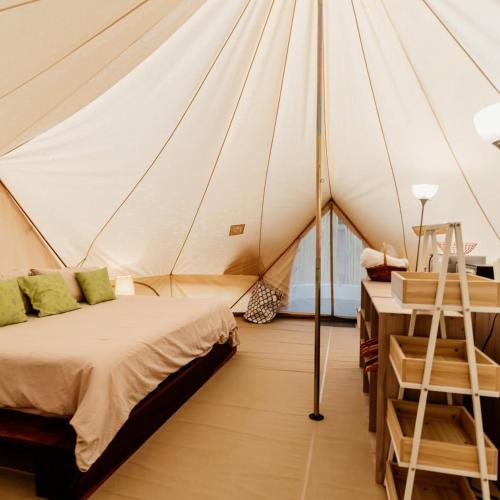 a bedroom with a bed in a tent at GuanaGlamp in Tamarindo
