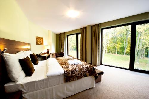 Habitación de hotel con cama y ventana grande en Hotel Zochova Chata - Adult friendly en Modra