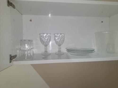 a shelf with three wine glasses and a plate on it at República Nunes e Silva in Vilhena