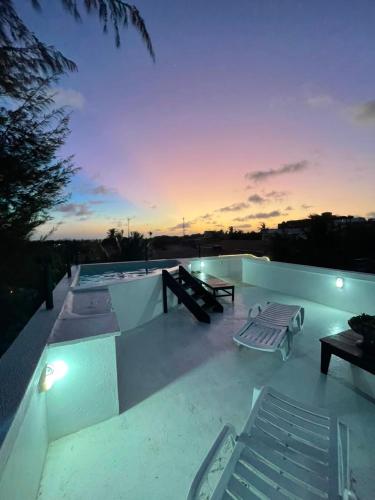 a patio with benches and tables on a roof at Villa Veríssimo in Jericoacoara