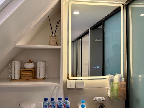 a bathroom with a sink with a mirror and water bottles at Duplex Garden Villa with Private Courtyard Jing'an Villa Near Metro Downtown Shanghai in Shanghai