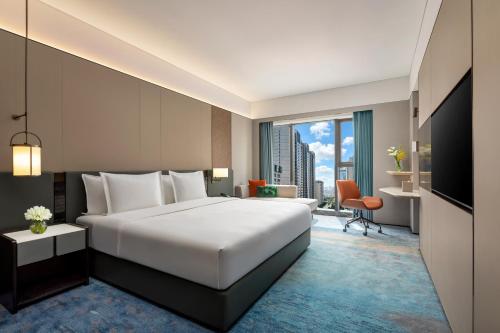 a hotel room with a bed and a large window at Crowne Plaza Dalian Kerren in Dalian