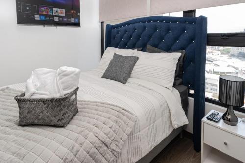 a bedroom with a large bed with a blue headboard at Ceiling INARA 1503 B in Guatemala