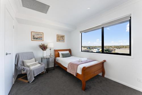 a bedroom with a bed and a window at Homenest in Gledswood Hills