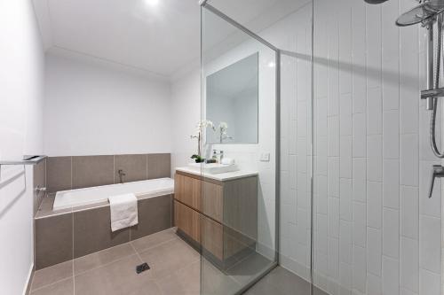 a bathroom with a tub and a sink and a shower at Homenest in Gledswood Hills