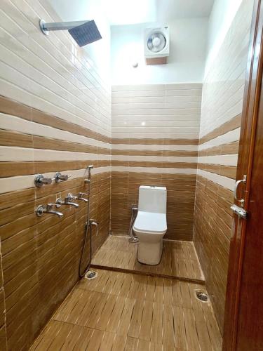 a bathroom with a toilet and a shower at Hotel Sada Shiv Inn in Deoghar