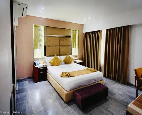 a bedroom with a large bed and a desk at Dhaka Unique Regency in Dhaka