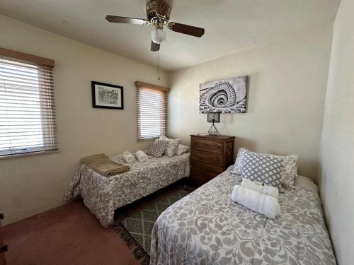 a bedroom with two beds and a ceiling fan at Sacred Heart House in Montebello