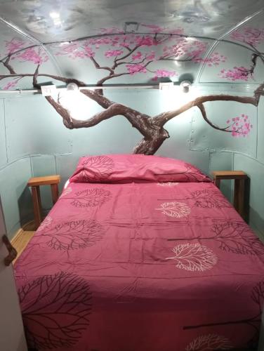 a bedroom with a tree branch above a bed at Mostepa in Carpintería