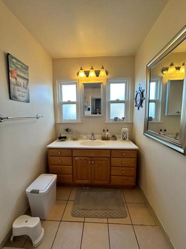a bathroom with a sink and a toilet and a mirror at Sacred Heart House in Montebello