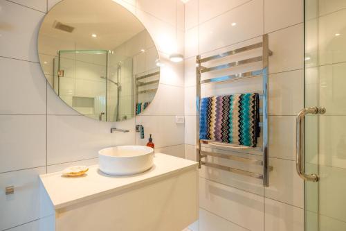 a bathroom with a sink and a mirror at Beachfront 25 The Strand Moana in Waiheke Island