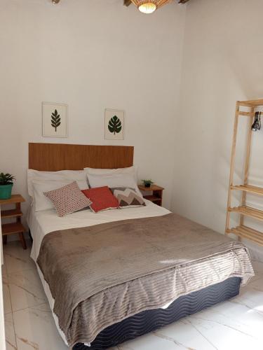 a bedroom with a large bed with two red pillows at Solar das pérolas Búzios 1 in Búzios