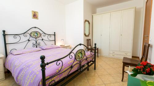 a bedroom with a bed with a purple comforter at Agriturismo Ca' Baccan in Cavallino-Treporti