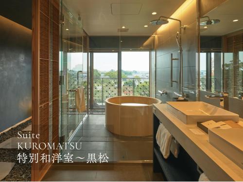ein Badezimmer mit Badewanne und großem Fenster in der Unterkunft Ohana in Yanagawa