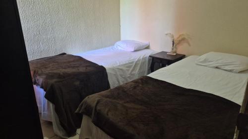 a room with two beds and two tables withitures at Residencial Acropolis in Sonsonate