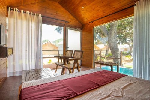 a bedroom with a bed and a large window at Leopard Inn Arugam Bay in Arugam Bay