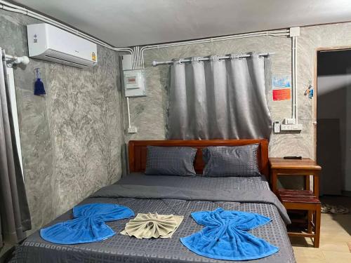 a bedroom with a bed with blue towels on it at Lung peiyk homestay in Ban Bang Bao