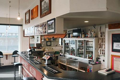 a bar in a restaurant with a counter and chairs at Hampden Hotel Murchison in Murchison