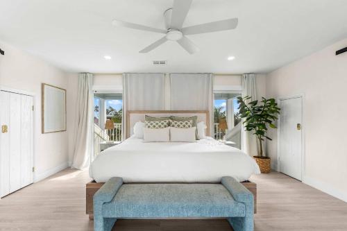 a white bedroom with a bed and a ceiling fan at Blanco Bay Key in Duck Key