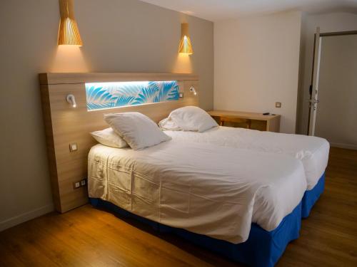 a hotel room with a large bed with two pillows at Le Pacifik Kone in Koné
