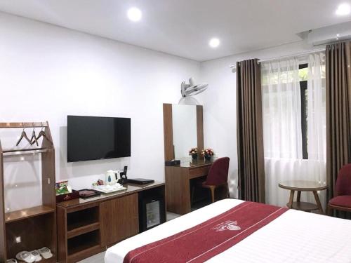 a hotel room with a bed and a television at Rosy Hotel Dương Nội in Hà Ðông