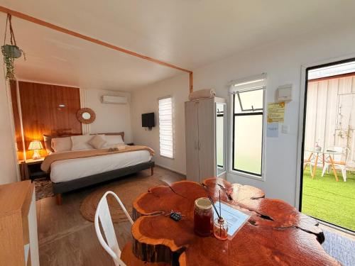 a bedroom with a bed and a table and a bed and a room at Casa Withe opción jacuzzi estadía villa alemana in Villa Alemana