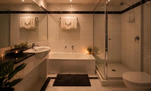 a bathroom with a tub and a sink and a toilet at ClickClock Hotel in Melbourne