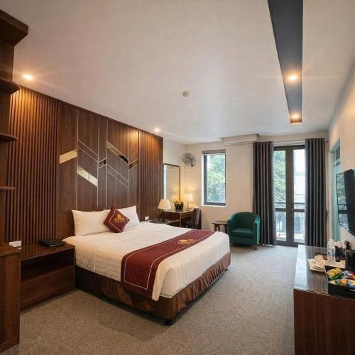 a large hotel room with a bed and a desk at Rosy Hotel in Hanoi