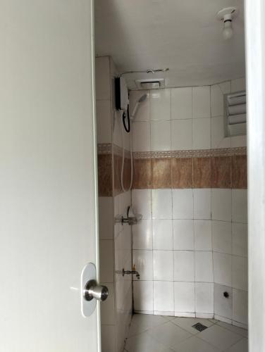 a bathroom with a shower with white tiles at Gigi's transient house in Baguio