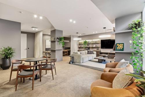 a living room with a couch and a table and chairs at Urban Rest Melbourne in Melbourne