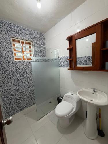 a bathroom with a toilet and a sink and a shower at Aparta hotel doble in Higuey