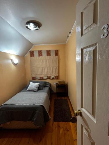 a bedroom with a bed in a room with a window at Hostal el valle in Angol