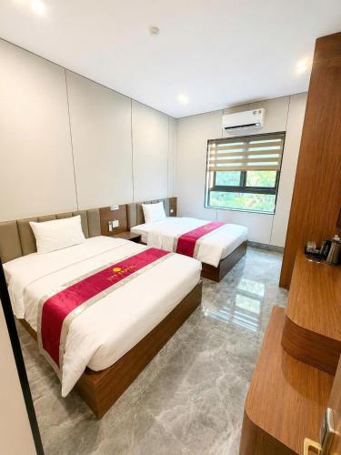 a bedroom with two beds and a window at HT Hotel Hà Tĩnh in Hà Tĩnh