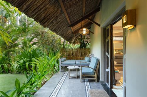 a porch with blue chairs and a table at Sailing Club Resort Mui Ne in Mui Ne