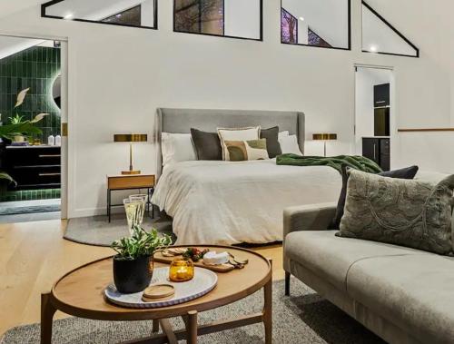 a bedroom with a bed and a table and a couch at The Sett in Sassafras