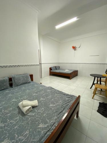 a bedroom with a large bed and a table at Nhà Nghỉ 36 in Ga Trảng Bôm