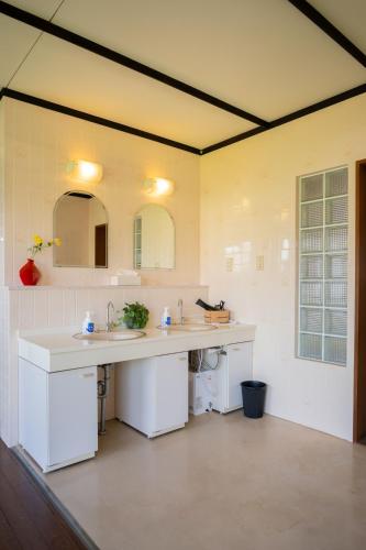 a bathroom with two sinks and two mirrors at guesthouse LAPPY in Ureshino