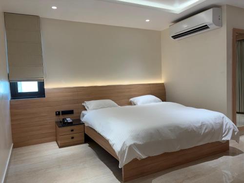 a bedroom with a large white bed and a window at M Convention Eluru in Elūru